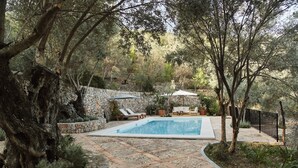 A pool area with stone walls, lounge chairs, and a stone pathway. - Can Escu - Villa in the Heart of the Tramuntana Mountains (Sóller)