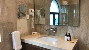 Un baño con un espejo grande, un lavabo y un perchero para toallas.