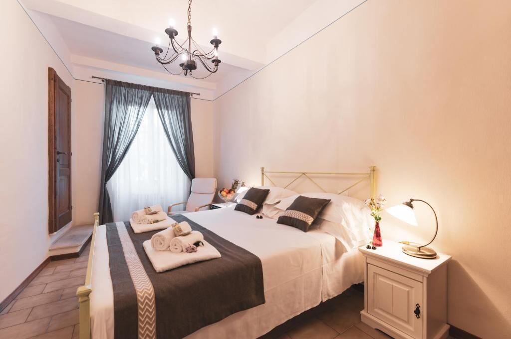 Ein Hotelzimmer mit Bett, Nachttisch, Lampe und einer Chandelierleuchtre.