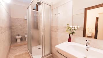 A modern bathroom with a walk-in shower, a bidet, and a large bathtub.