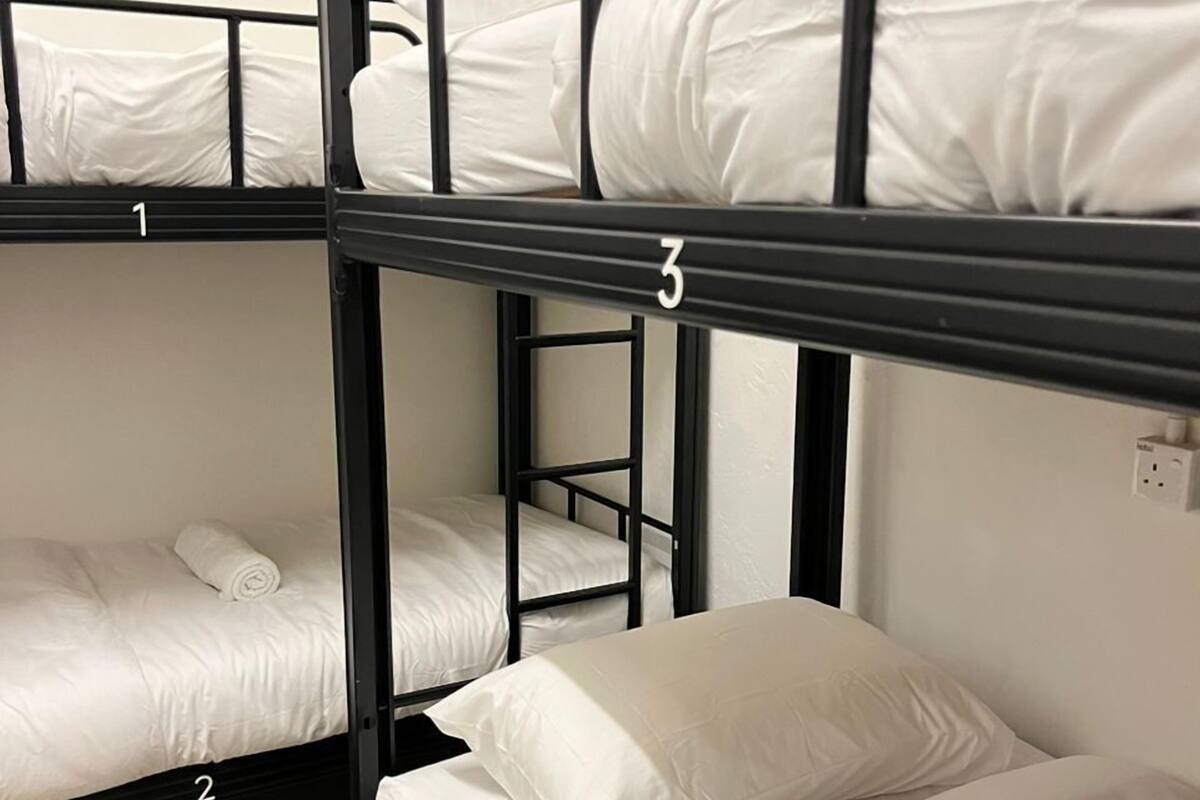 Een slaapkamer met stapelbedden, elk voorzien van een nummer.