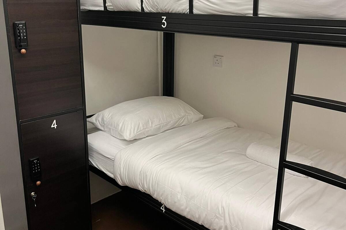 Een slaapkamer met een stapelbed, een garderobe en een bedieningspaneel.