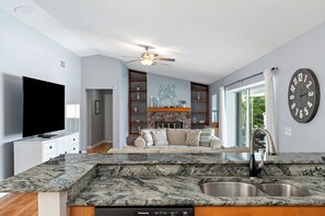 A modern kitchen with granite countertops, a built-in dishwasher, and a stainless steel sink.