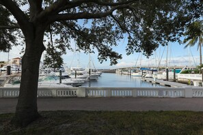 A marina with boats docked, a tree in the foreground, and a bridge in the background. - Spacious Pet Friendly 3BR Home W/ Private Pool & Spa in Palma Sola (Bradenton)
