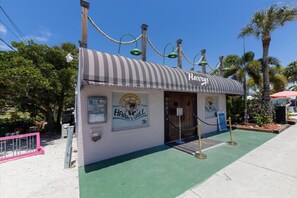 A small, single-story building with a striped awning and a sign that reads "Harry's Grill". - Spacious Pet Friendly 3BR Home W/ Private Pool & Spa in Palma Sola (Bradenton)
