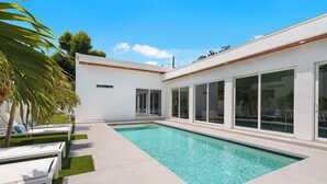 A modern house with a swimming pool, large windows, and a patio area. - Luxury Home, Pool, Mins to Top Beaches and Downtown Sarasota (Sarasota)