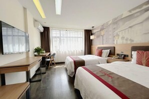 Quarto de hotel com duas camas, uma escrivaninha, uma cadeira, uma televisão e uma janela com cortinas.
