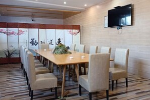 A conference room with a long table, six chairs, a television mounted on the wall, and a decorative screen with floral patterns. - Shankee Chain Hotel (Yancheng Municipal Government Jinying Julonghu Store) (Yancheng)