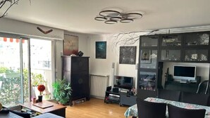 A modern living room with a dining area, a fireplace, and a television.