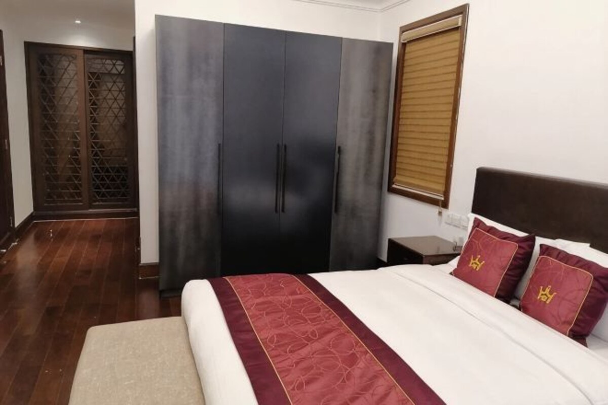 Un dormitorio con cama, armario y ventana.