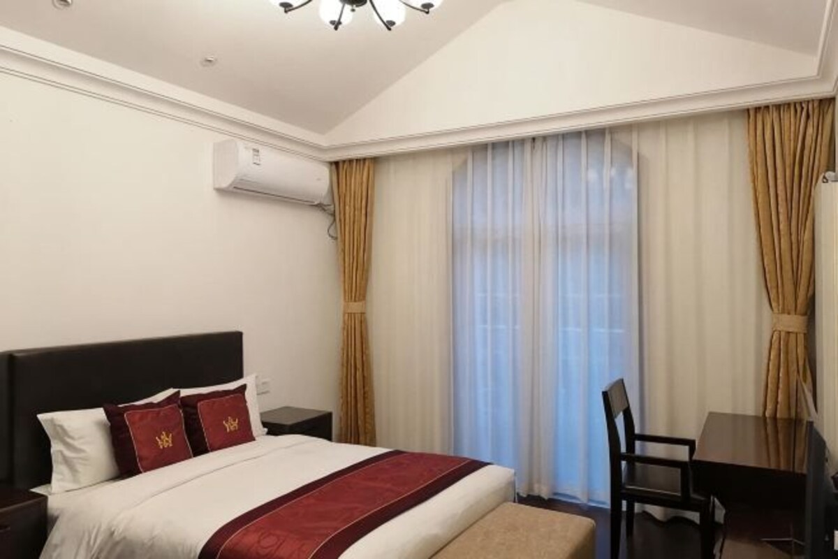 Una habitación de hotel con una cama grande, un escritorio y una silla.