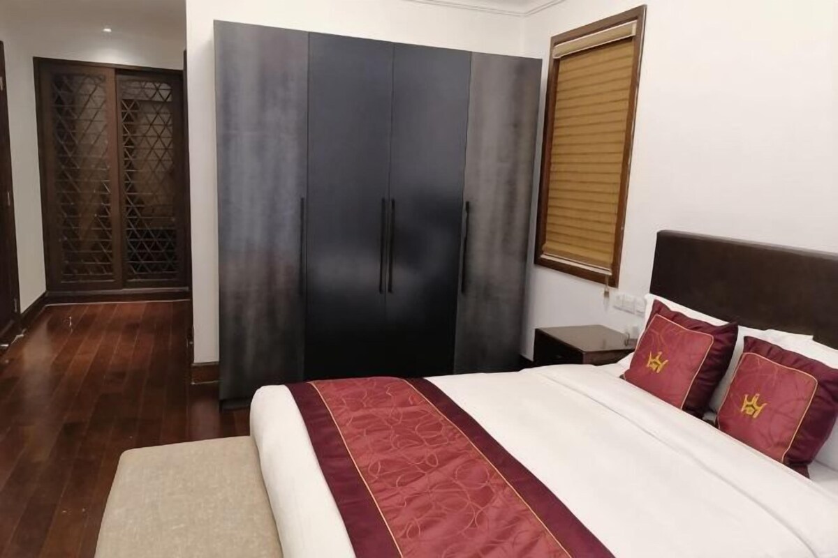 A bedroom with a bed, a wardrobe, and a window.