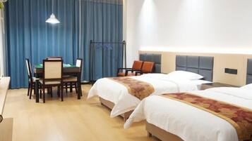 A hotel room with two beds, a desk, and a chair.