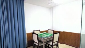 A corner room with a table and four chairs, a blue curtain, and a wooden wainscoting. - Yichun Yue Hotel (Yichun)