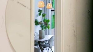 A modern interior with a dining area featuring a table, chairs, and hanging pendant lights.
