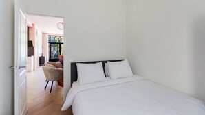Quarto com cama, uma cadeira e vista para uma área de refeições.