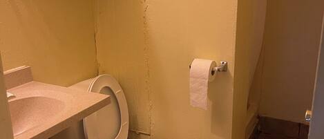A small bathroom with a toilet, a sink, and a towel rack.