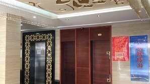 Un pasillo interior con dos ascensores, uno con una puerta de diseño geométrico y el otro con una puerta lisa.