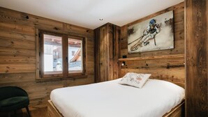 Ein schlichtes Schlafzimmer im Chalet-Stil mit einem Bett, einem Fenster und einem Bild an der Wand.