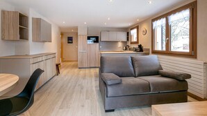 Un interior moderno con sofá, mesa de comedor y zona de cocina.