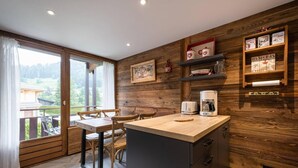 Una cocina moderna con detalles de madera, un comedor con vistas y una cafetera.
