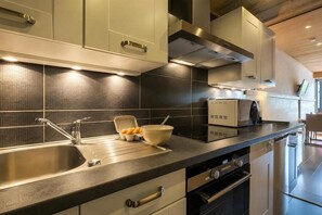 Eine moderne Küche mit Edelstahlgeräten, einer doppelten Spüle und einem eingebauten Backofen.