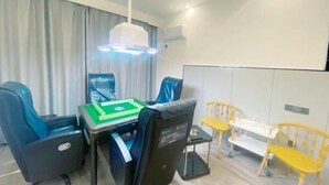 Een moderne kamer met een eettafel, blauwe en gele stoelen, en een klein witte tafeltje met een dienblad.