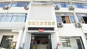 Een gebouw met een bord waarop Chinese karakters staan, wat suggereert dat het een hotel of bedrijf is.