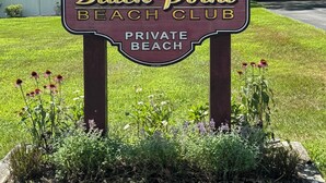 A sign for Black Point Beach Club marking its 75th anniversary, surrounded by a grassy area with flowers. - 4-BdRm Home at Black Point Beach, East Lyme - WiFi + AC, Pet Friendly! (East Lyme)