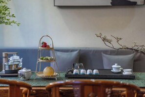 A tea set on a tray with a tiered stand, a bowl, and a teapot on a table. - Home Inn (Zhongyi) (Lijiang)