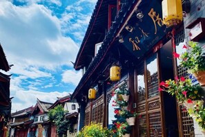 A traditional building with wooden architecture, a sign with Chinese characters, and hanging lanterns. - Home Inn (Zhongyi) (Lijiang)