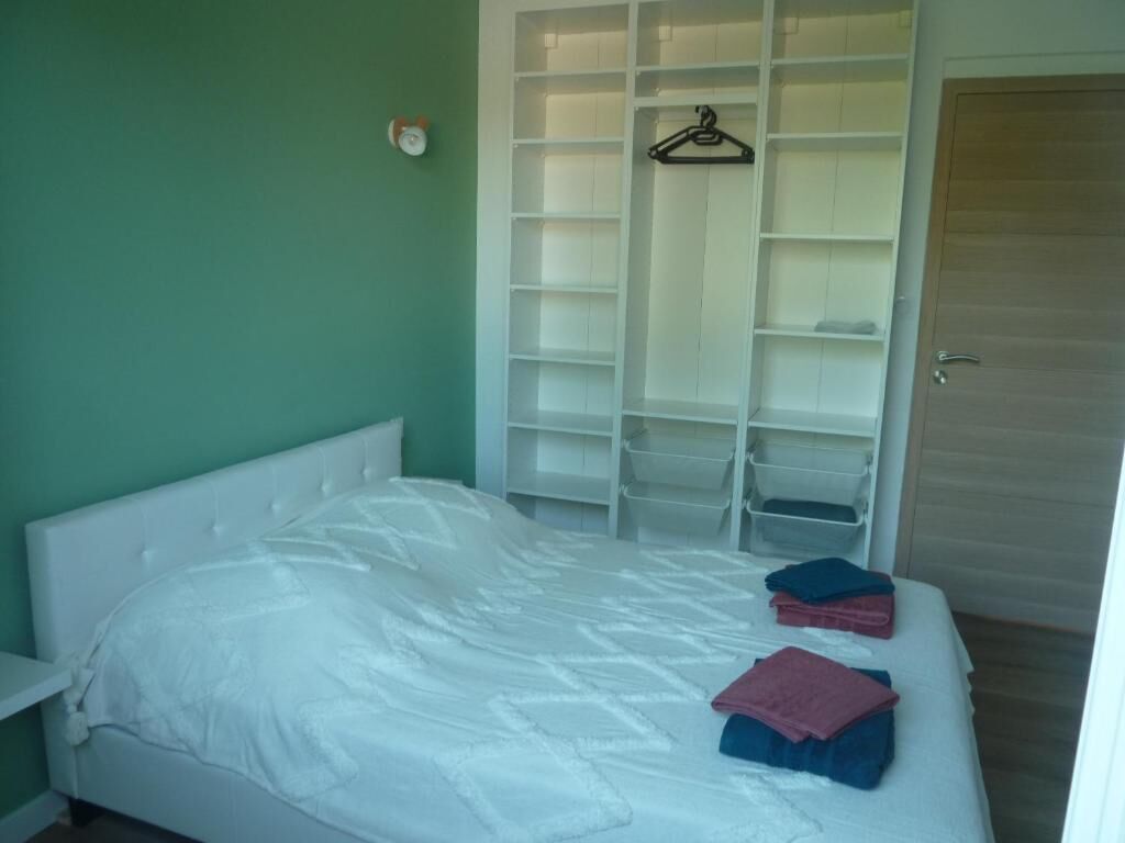 Une chambre à coucher avec un lit, une armoire blanche et une porte.