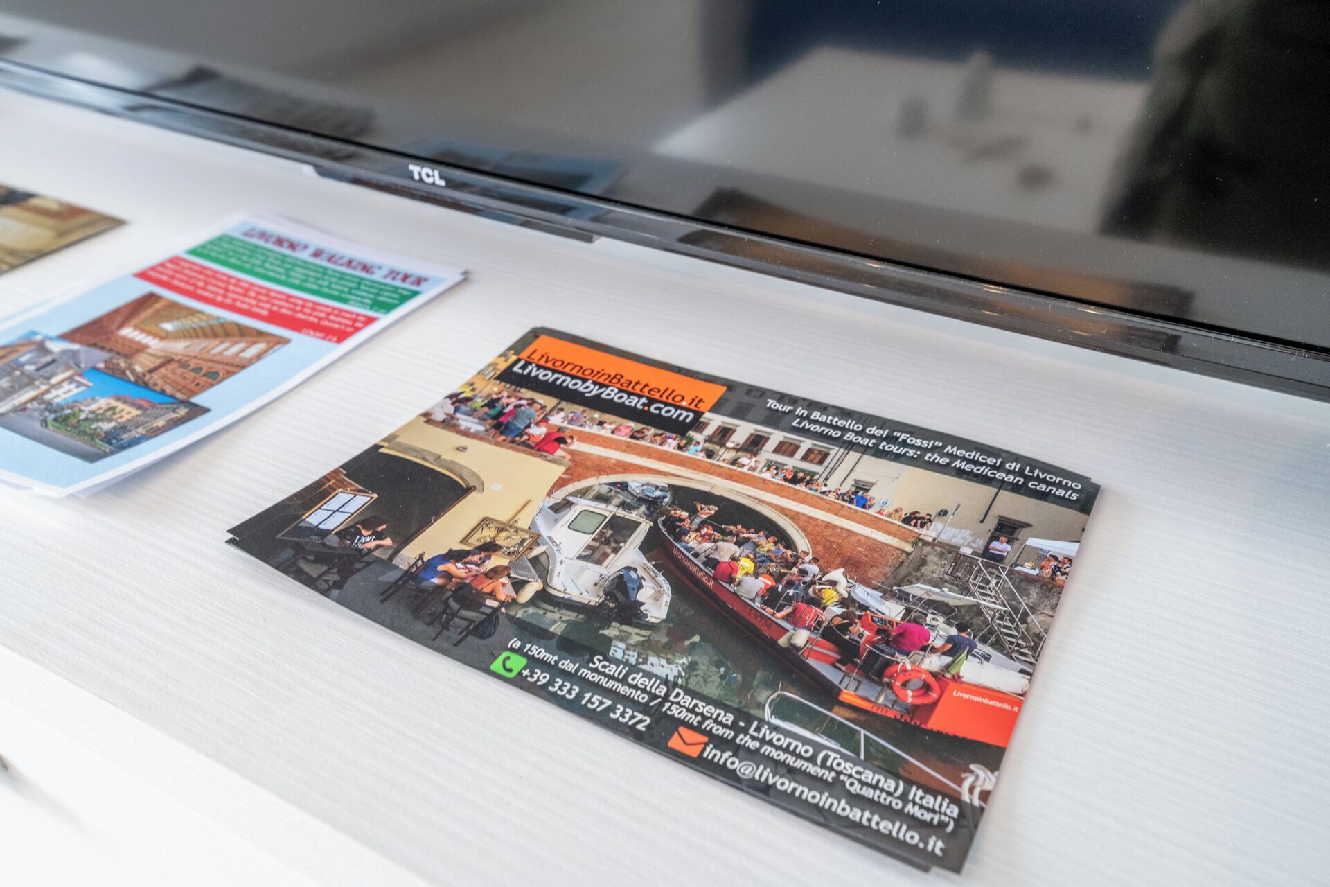 Une brochure contenant une photo d’une excursion en bateau, les coordonnées et l’adresse d’un site web.