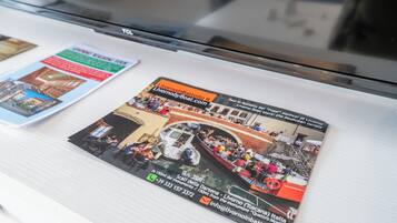Une brochure contenant une photo d’une excursion en bateau, les coordonnées et l’adresse d’un site web.