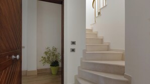 Una escalera con una puerta de madera y una planta en maceta.