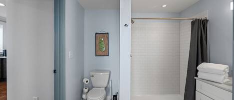 Un baño con inodoro, ducha y lavamanos.