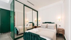 A hotel room with a large bed, two bedside tables, a mirror, and a green wardrobe. - GuestReady - Stylish stay with a balcony (Porto)