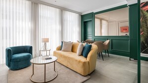 A modern living room with a beige sofa, a blue armchair, and a round coffee table. - GuestReady - Stylish stay with a balcony (Porto)
