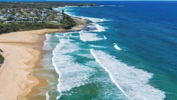 A coastal landscape with a sandy beach and ocean waves. - Racecourse Beach Coast Shack (Ulladulla)