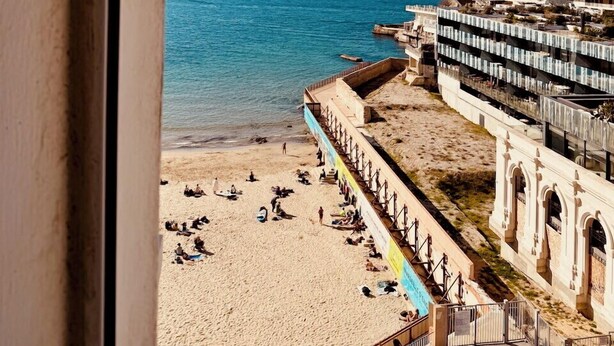 A beach with a view of the sea and a building with multiple balconies. - Charming Apartment at 10mn du Vieux Port (Marseille)