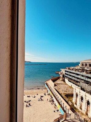 Une plage avec vue sur la mer et un immeuble doté de nombreux balcons.