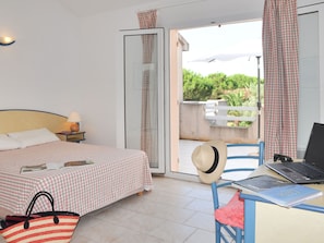 Guests can enjoy a comfortable stay in this cozy room featuring a bed, a bedside table with a lamp, and a chair.