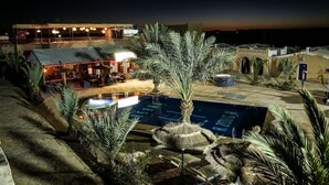 A rooftop bar with outdoor seating and a swimming pool. - Kasbah Merzouga (Taouz)