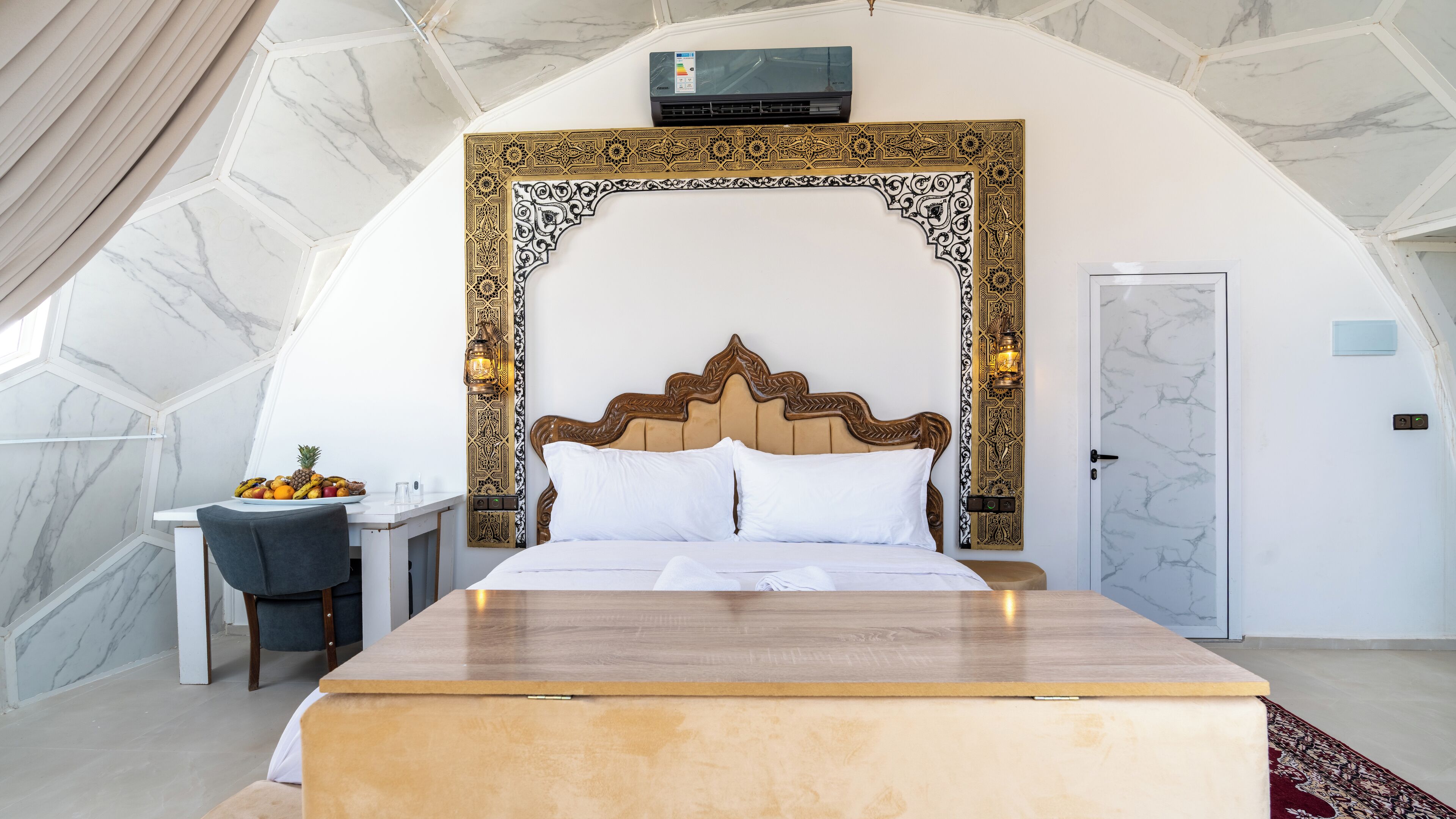 Une chambre avec un grand lit, un bureau et une chaise.