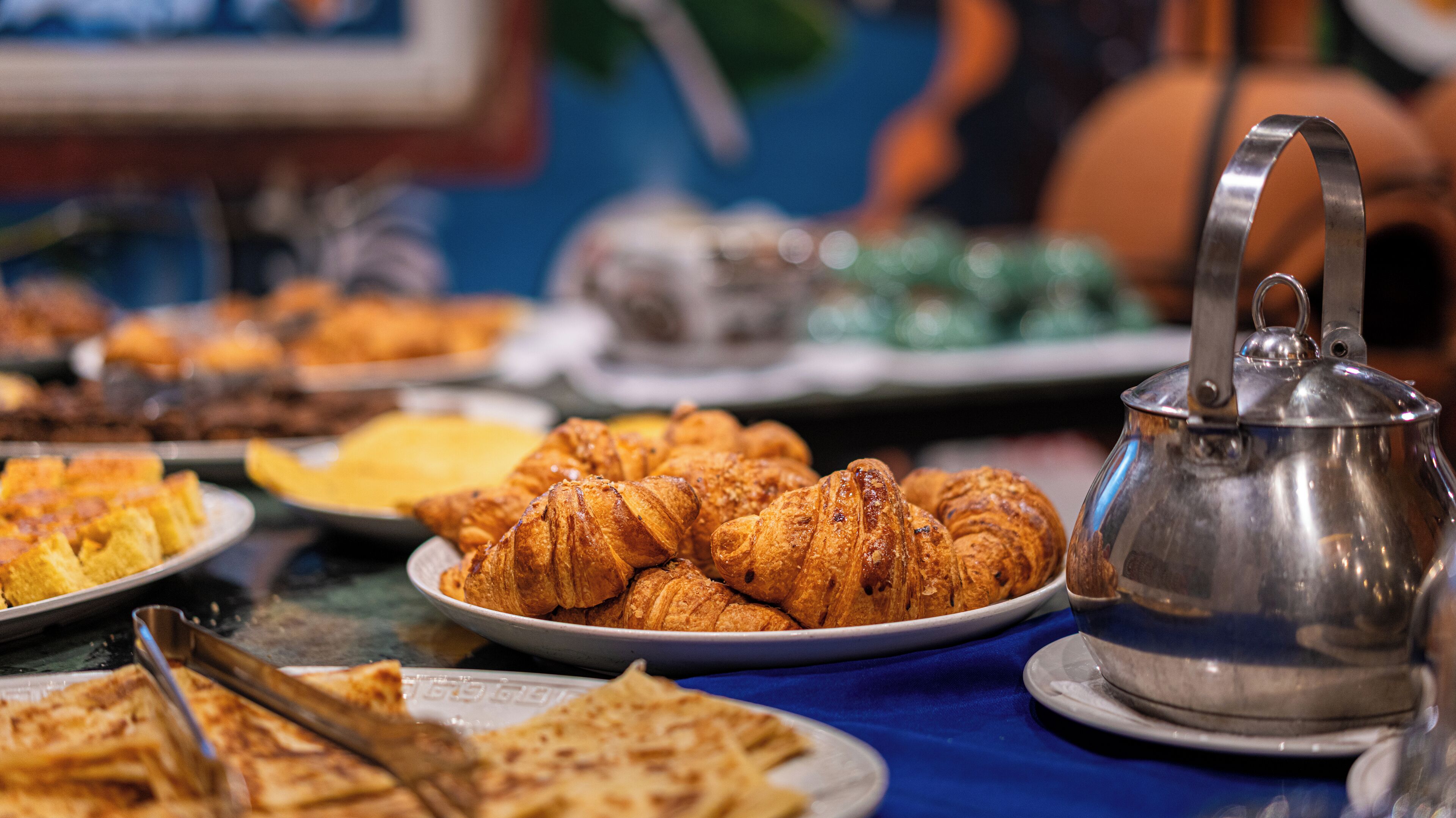 A buffet with various food items including pastries and a teapot.