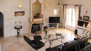 Ein Wohnzimmer mit Kamin, Fernseher, Sofa und Couchtisch.