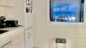 Eine Küche mit einem Fenster und Blick auf einen Balkon.