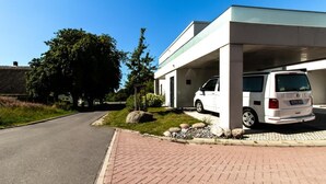 A modern building with a white van parked under a covered area.