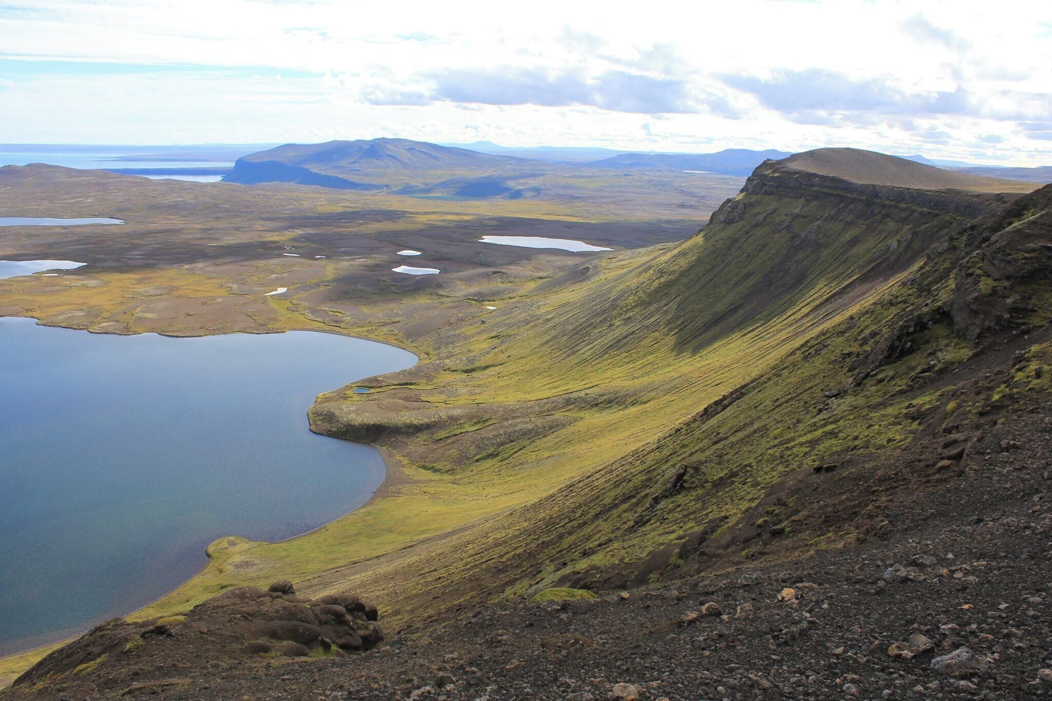 A mountainous landscape with a lake and distant hills.