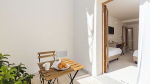 A small, bright room with a wooden table, a chair, and a bed. There is a window providing natural light. - Ausentu Guest House (Tortoli)